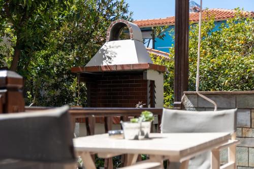a outdoor grill with a table and chairs at Stefanias apartment in Neos Marmaras