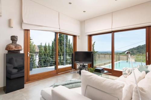 a living room with a couch and a tv and windows at Can Vicens -Mancor- in Mancor del Valle