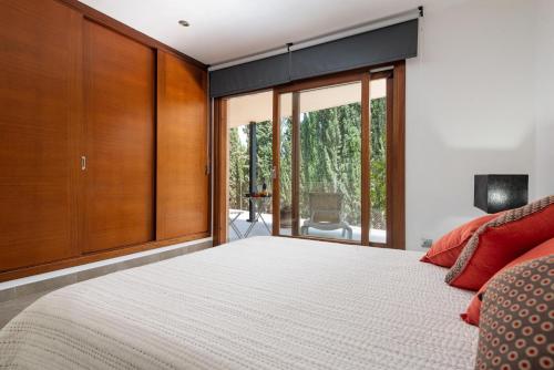 a bedroom with a large bed and sliding glass doors at Can Vicens -Mancor- in Mancor del Valle
