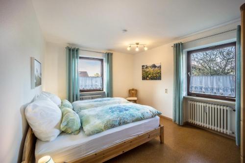 una camera con un letto e due finestre di Haus Bergliebe - Breitenbergblick a Pfronten