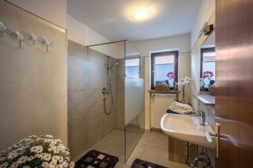 uma casa de banho com um chuveiro e um lavatório. em Haus Bergliebe - Breitenbergblick em Pfronten