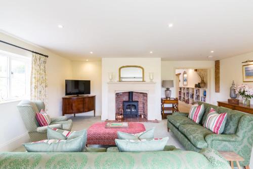 a living room with two couches and a fireplace at Chater Barn in Leicester