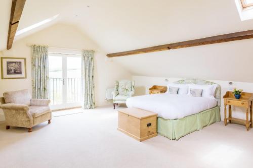 a bedroom with a large bed and a chair at Chater Barn in Leicester