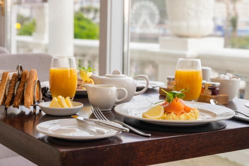 a table with plates of food and glasses of orange juice at St George's Hotel - Llandudno in Llandudno