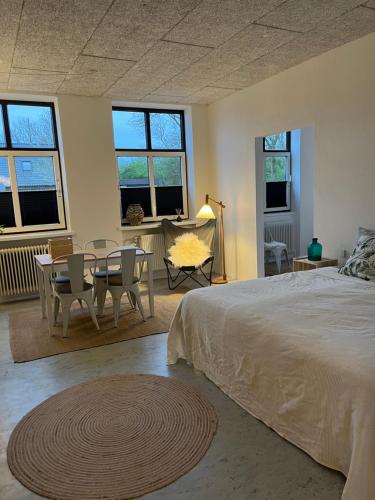 - une chambre avec un lit, une table et des chaises dans l'établissement Room 6 - Hawkraft Kulturhotel, à Vestervig