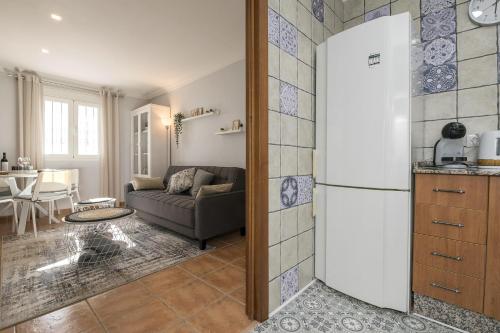 a kitchen and a living room with a couch at Rincon de los Deseos in Benamahoma