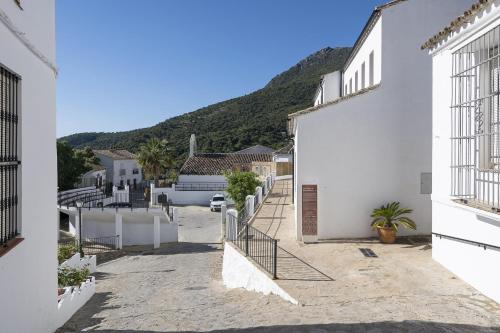 a street with white buildings and a mountain at Rincon de los Deseos in Benamahoma