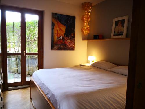 Un dormitorio con una gran cama blanca y una ventana en Chalet Luna, en Caspoggio
