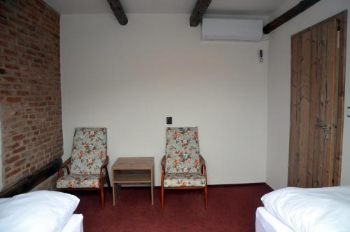 two chairs and a table in a room at Penzion U Cyrila in Moravská Třebová