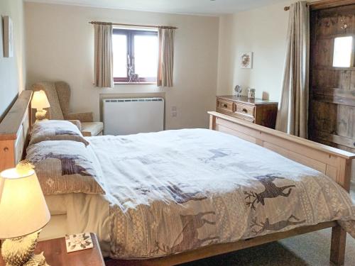 ein Schlafzimmer mit einem Bett und einem Tisch mit einer Lampe in der Unterkunft Hillcrest Cottage in Broxa