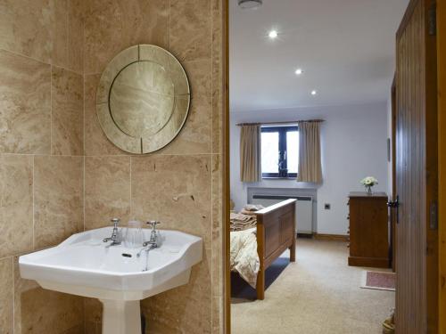 ein Bad mit einem Waschbecken und ein Schlafzimmer in der Unterkunft Hillcrest Cottage in Broxa