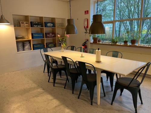 Room 6 - Hawkraft Kulturhotel في Vestervig: غرفة طعام مع طاولة وكراسي