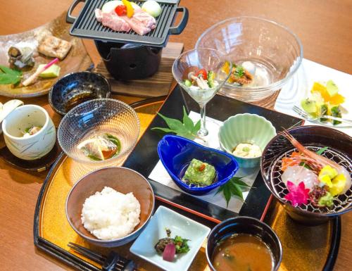 uma mesa coberta com tigelas e pratos de comida em LiVEMAX RESORT Hakone Sengokuhara em Hakone