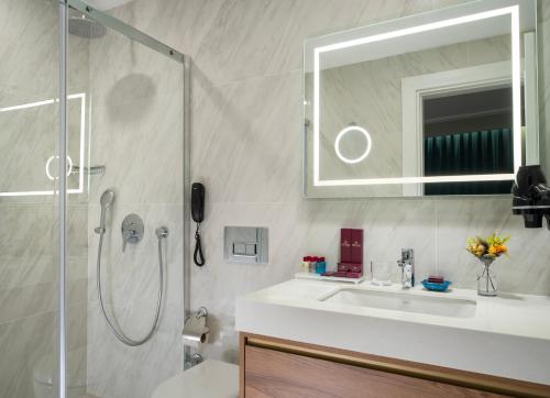 a bathroom with a shower and a sink and a mirror at Royan Suites in Istanbul