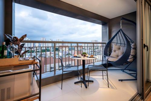 a balcony with a hammock and a table at Intercity Tatuapé in Sao Paulo