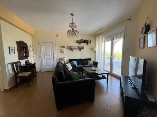a living room with a couch and a tv at Villa Palma in Skala Rachoniou
