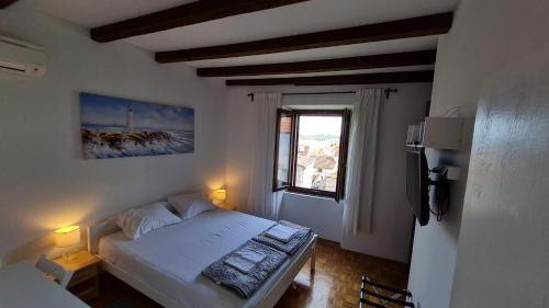 ein kleines Schlafzimmer mit einem Bett und einem Fenster in der Unterkunft Cunka House in Vis