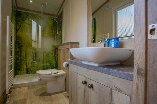 a bathroom with a sink and a shower and a toilet at Mersea Island by Away Resorts in Colchester