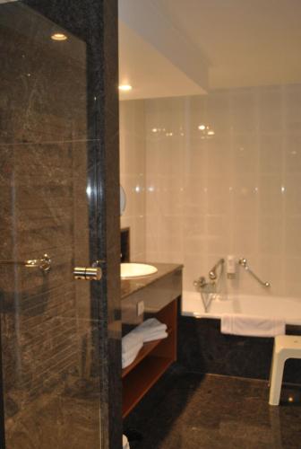 a bathroom with a shower and a sink and a tub at La Roseraie. Gaume-Ardenne-lacuisine sur Semois. in Florenville