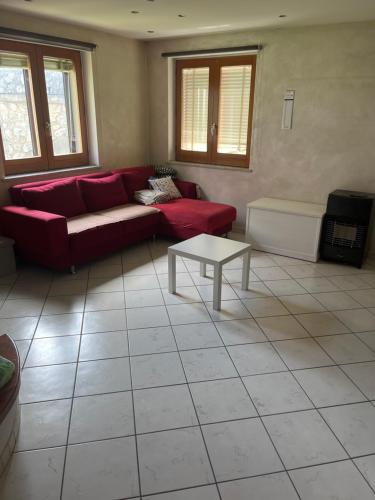 Sala de estar con sofá rojo y mesa de centro en La casa sul ponte, en Castelgrande