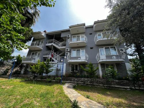 an apartment building with balconies and a yard at New Golden Gate Butik Otel in Muğla