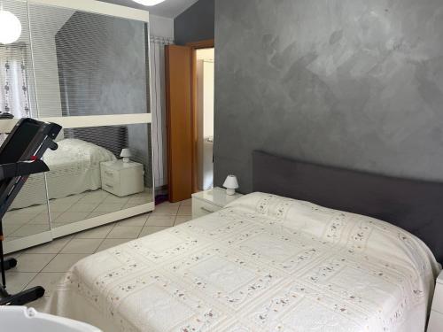 1 dormitorio con 1 cama grande y espejo en La casa sul ponte, en Castelgrande