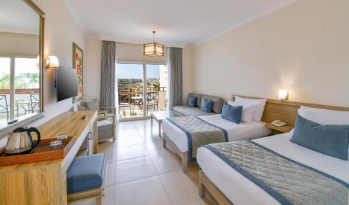 Iberotel Casa Del Mar Resort في الغردقة: غرفة فندقية بسريرين وبلكونة