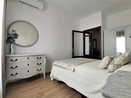 um quarto com uma cama e uma cómoda com um espelho em Casa Cervantes Toledo em Toledo