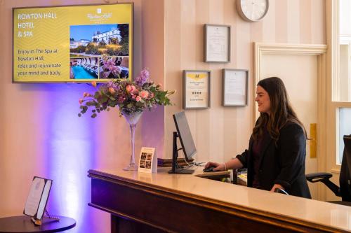 a woman sitting at a cash register in a waiting room at St George's Hotel - Llandudno in Llandudno