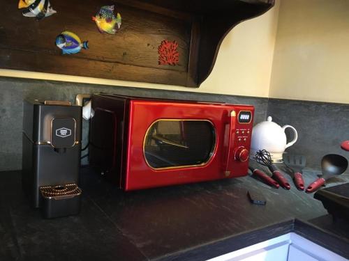 un four micro-ondes rouge installé au-dessus d'un comptoir de cuisine dans l'établissement Casa Rossa, à Portovenere
