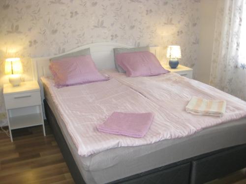 - un lit blanc avec 2 serviettes violettes dans l'établissement Rt-huoneisto,Kulnevintie 2 as 3, 62300 HÄRMÄ, à Härmä