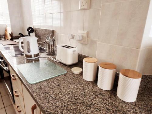 a kitchen with a counter top with two stools at 1 St Daniel in Ramsgate