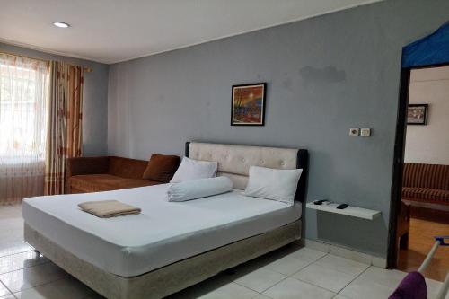 a bedroom with a bed and a couch at Pondok Seruni Kemanggisan Jakarta in Jakarta