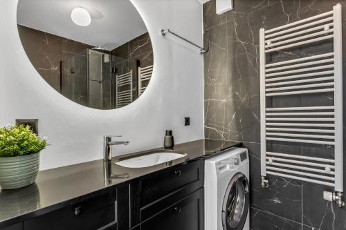 a bathroom with a sink and a washing machine at Snorrabraut Apartments By Alva in Reykjavík