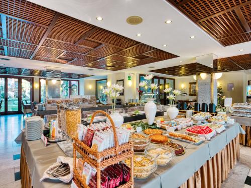 a buffet line with food in a restaurant at Parc Hotel Gritti in Bardolino