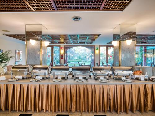 a dining room with a table with a bunch of chairs at Parc Hotel Gritti in Bardolino