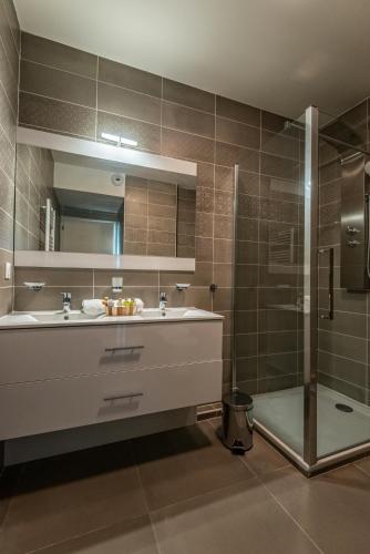 une salle de bain avec un lavabo et une douche dans l'établissement Olydea Beausoleil, à Beausoleil