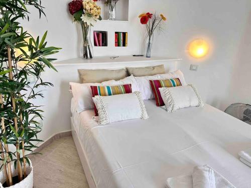 - un canapé blanc avec des oreillers dans une chambre avec des plantes dans l'établissement Mirador Paraiso: Superb Sea View, à Playa Paraiso