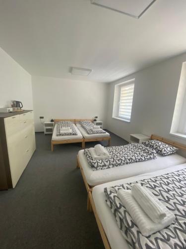 a room with three beds in it with a row at Penzion Puk in Hrob