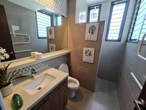 een badkamer met een wastafel, een toilet en een spiegel bij Seri Alam Y19 Luxury Spacious Villa in Masai