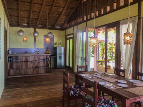 a dining room with a table and a kitchen at Casa Paraíso - Little Corn Island in Little Corn Island