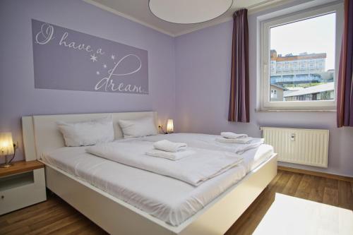 ein Schlafzimmer mit einem weißen Bett und einem Schild mit der Aufschrift „Have a dream“ in der Unterkunft strandnah, Balkon, AHOI Erlebnisbad gratis in Sellin - Strandresidenz Brandenburg FeWo 14 in Göhren