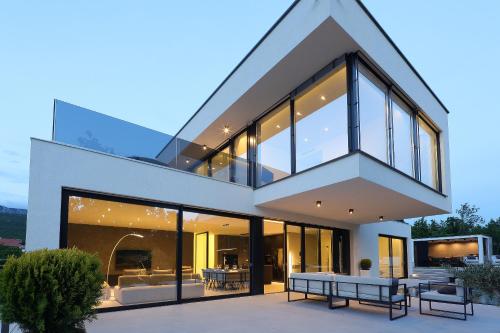 a house with large glass doors and windows at Luxury Villa Cloer, Jadranovo - Sauna,Steam room, 2 Jacuzzis in Jadranovo