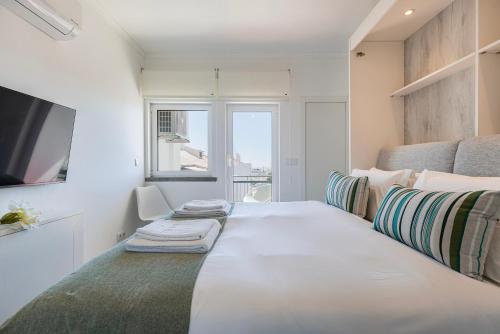 1 dormitorio con 1 cama blanca grande y ventana en Green Oasis in Parede by LovelyStay, en Parede