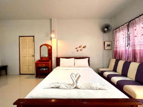 a bedroom with a bed and a couch at พิณทอง รีสอร์ท in Khlong Thom