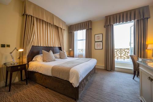 ein Schlafzimmer mit einem großen Bett und einem großen Fenster in der Unterkunft St George's Hotel - Llandudno in Llandudno