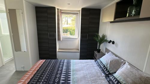 a bedroom with a bed and a window at MobilHome 2 chambres 229 dans Camping 4 étoiles in Pont-Aven