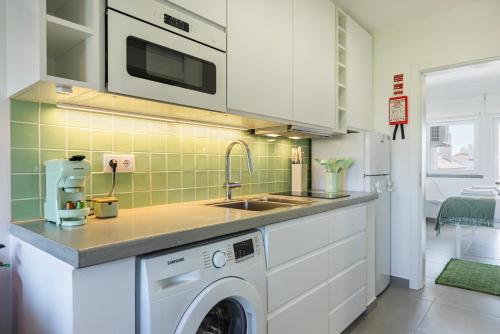 a kitchen with a sink and a washing machine at Green Oasis in Parede by LovelyStay in Parede