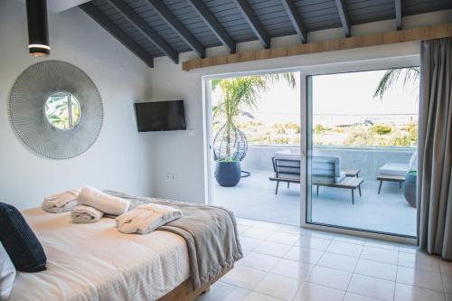 a bedroom with a bed and a view of a patio at JnS Faliraki Penthouse in Kallithea Rhodes
