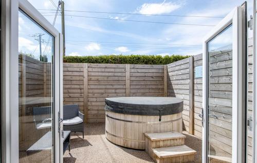 un patio con barril, mesa y silla en Mersea Island by Away Resorts, en Colchester
